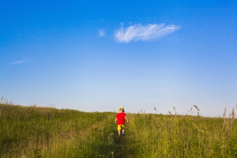 Mari boy walking in rural field