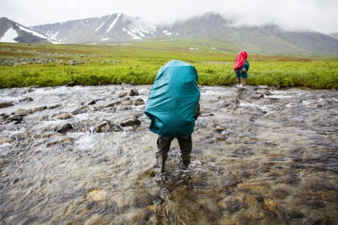 Backpackers crossing remote stream