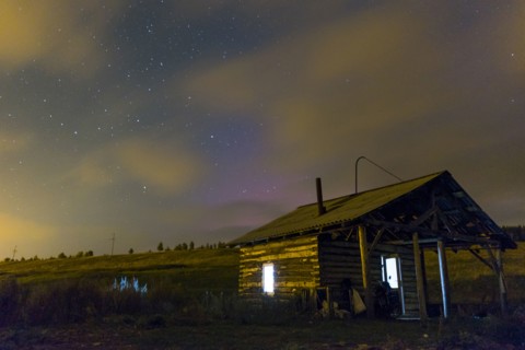 Cabin in rural field at night