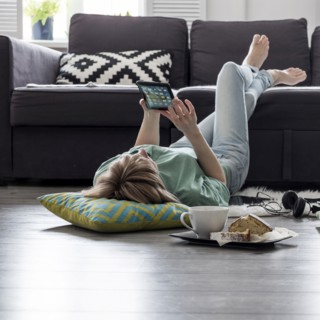 Caucasian woman using digital tablet on floor