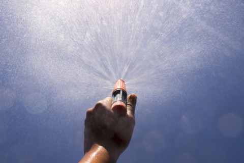 Mari boy spraying nozzle to blue sky