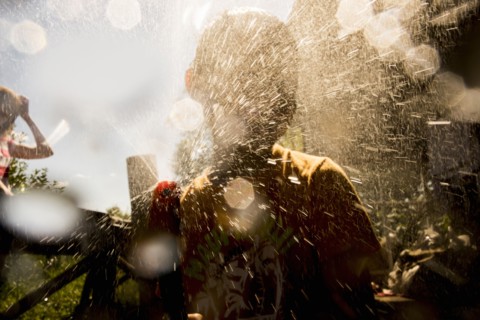 Back lit Mari boy spraying hose