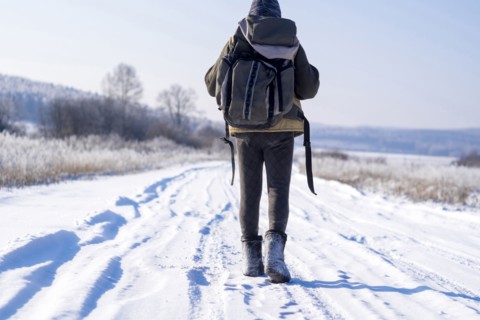 Caucasian man backpacking on snowy road