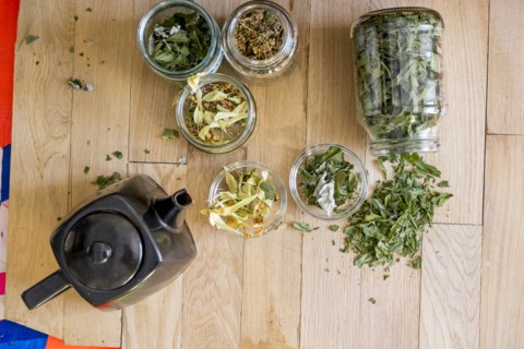 Teapot and tea leaves on table