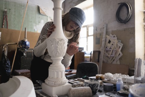 Caucasian sculptor carving plaster piece