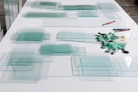 Piles of glass and glass cutter on white table