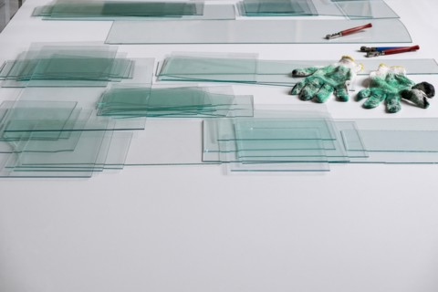 Piles of glass and glass cutter on white table