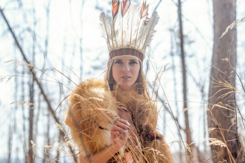 Caucasian woman wearing headdress in forest