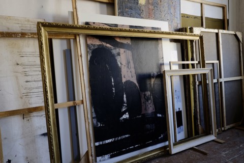 Paintings and frames leaning on wall