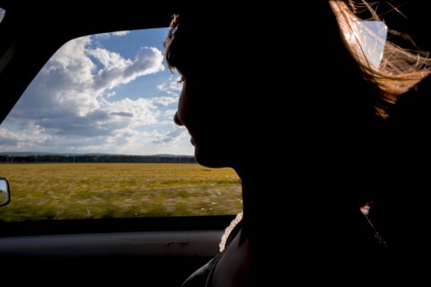 Silhouette of smiling woman passenger in car