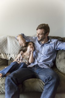 Father and daughter sitting on sofa