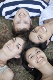 Friends laying in formation in grass