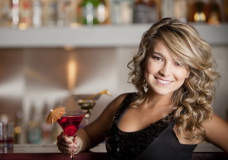 Hispanic woman drinking martini