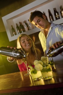 Hispanic bartenders preparing cocktails in bar