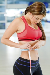 Hispanic woman measuring waistline