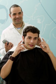 Hispanic Barber listening to client in barber shop