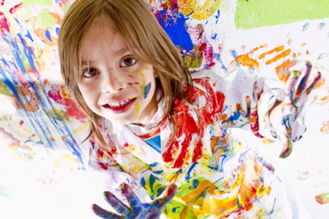 Messy Hispanic girl finger painting