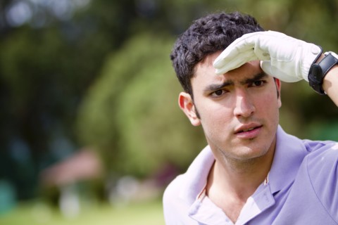 Hispanic man searching for golf ball