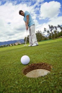 Hispanic man putting golf ball