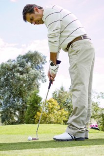 Hispanic man putting golf ball