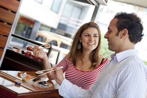 Hispanic couple eating sushi together