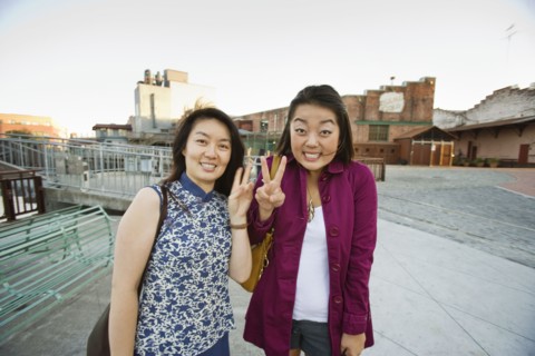 Chinese mother and daughter making peace sign