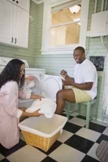 African husband helping wife fold laundry