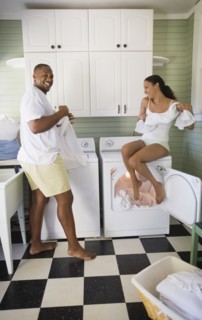 Playful couple folding laundry