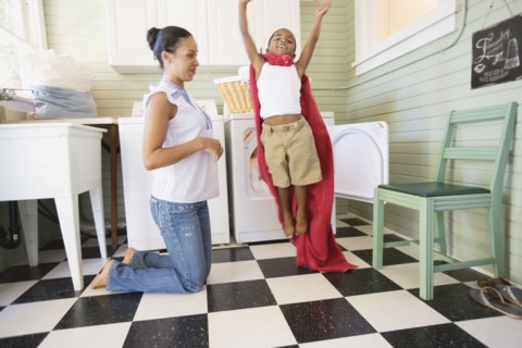Mixed race boy using towel to play superhero