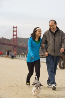 Chinese father and daughter walking dog