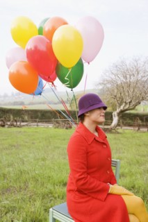 Mixed race woman holding colorful bunch of balloons
