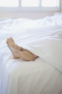 Woman's feet on end of bed