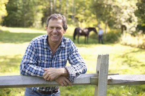 Caucasian man leaning on wooden fence