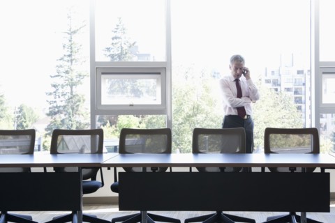 Caucasian businessman using cell phone in conference room