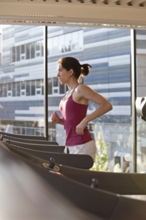 Woman running on treadmill in health club