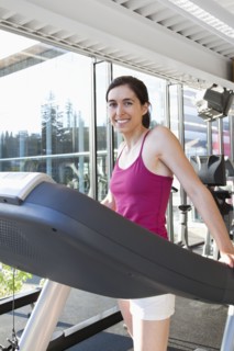 Smiling woman on treadmill in health club