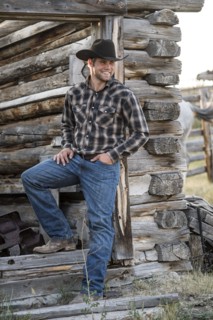 Caucasian cowboy leaning in doorway of cabin
