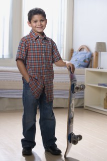 Hispanic boy holding skateboard