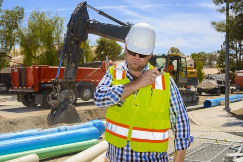 Caucasian construction worker listening to walkie-talkie