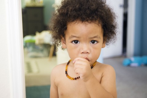 Naked Mixed Race baby boy sucking thumb