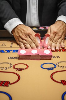 Dealer shuffling cards at baccarat table