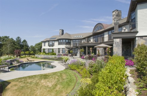 Rear exterior large neo eclectic home with swimming pool