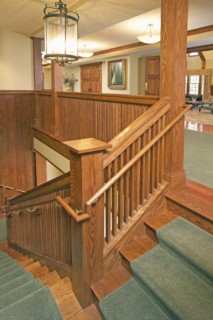 Wooden staircase with carpet runner in home