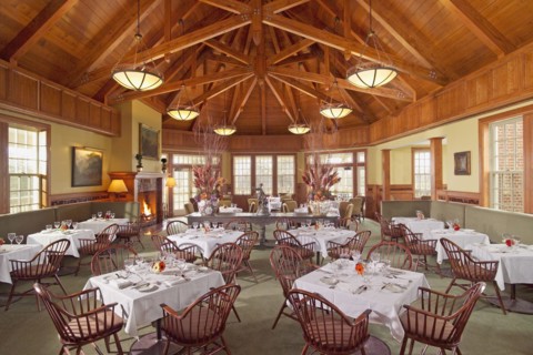 Grand dining room with several tables and wooden ceilings