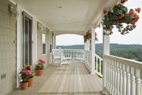 Large front porch of shingle style home with great view of tree tops