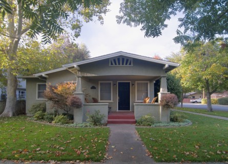 Front exterior view of a green bungalow