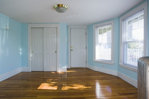 Empty room in apartment with hardwood floor and heater