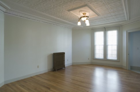Empty room in apartment with hardwood floor and heater