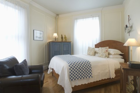 Bed and armchair in small studio apartment