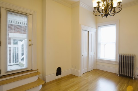Empty room in apartment with hardwood floor and heater